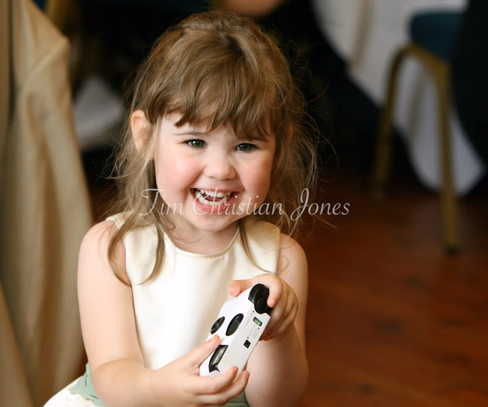 Leeds, West Yorkshire Wedding Photographer Captured a cute child at the wedding smiling with a single use camera