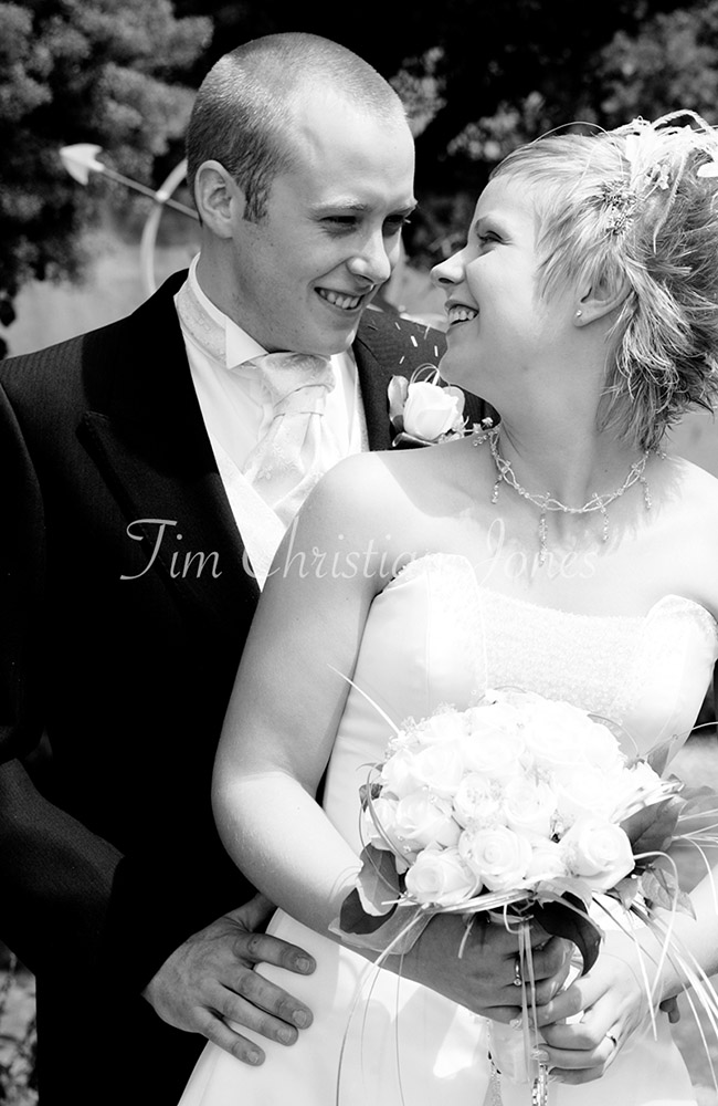 Candid black and white couple portrait — natural smiles shared in a quiet unposed moment.