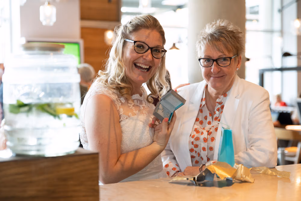 Clare and Tracey exchange gifts during their drinks reception at DoubleTree Hilton in Leeds