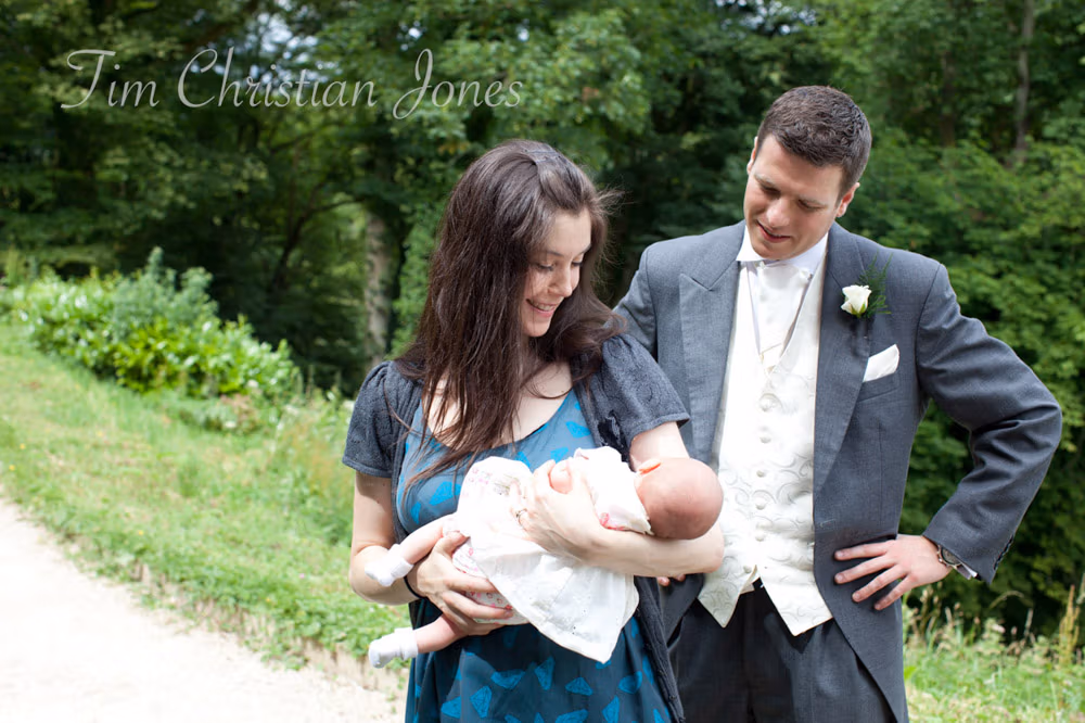 Groom admiring a baby held by a guest before the ceremony at the Temple of Apollo
