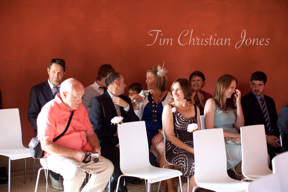 Guests seated inside the Temple of Apollo, red walls and sunlight from the open doorway
