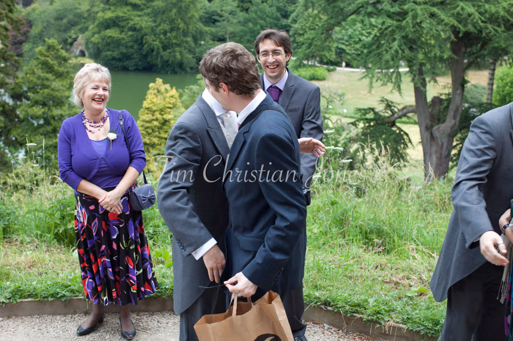 Groom greets arriving guests with warm smiles before the wedding ceremony
