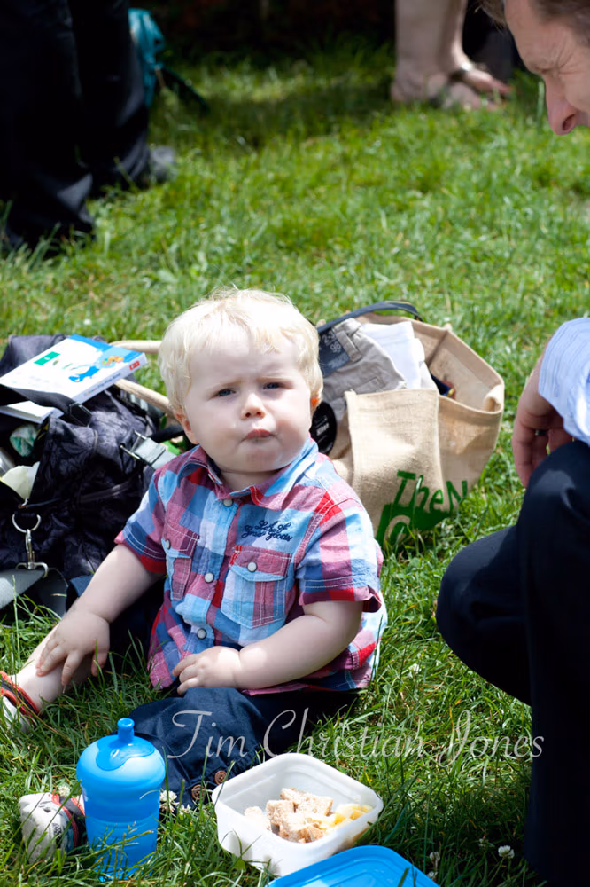 Young boy smiles while eating, enjoying the wedding food