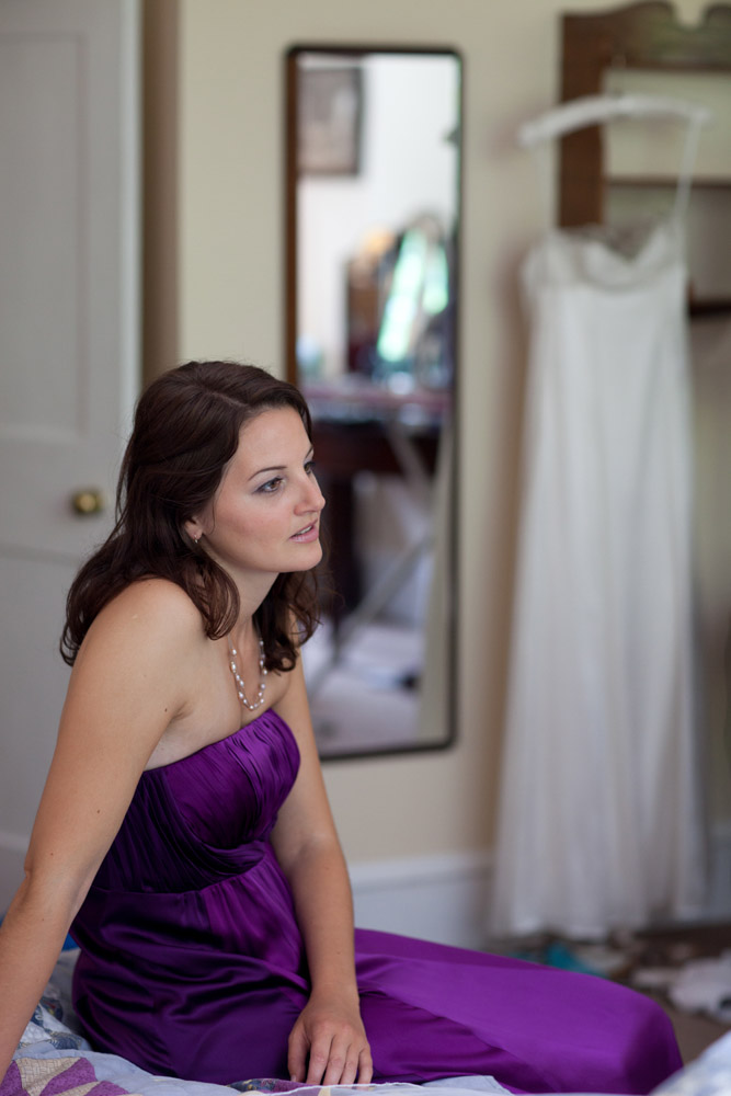 Bridesmaid sat with bride's dress behind her - Destination Leeds based wedding photographer