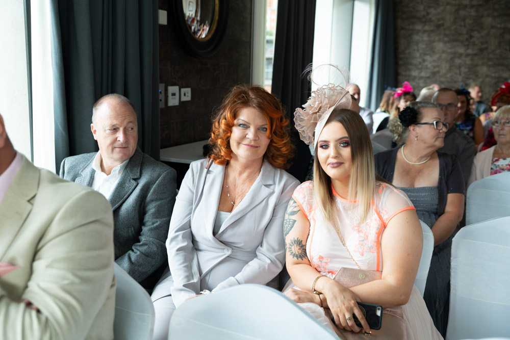 A happy wedding guest family posing for a photo