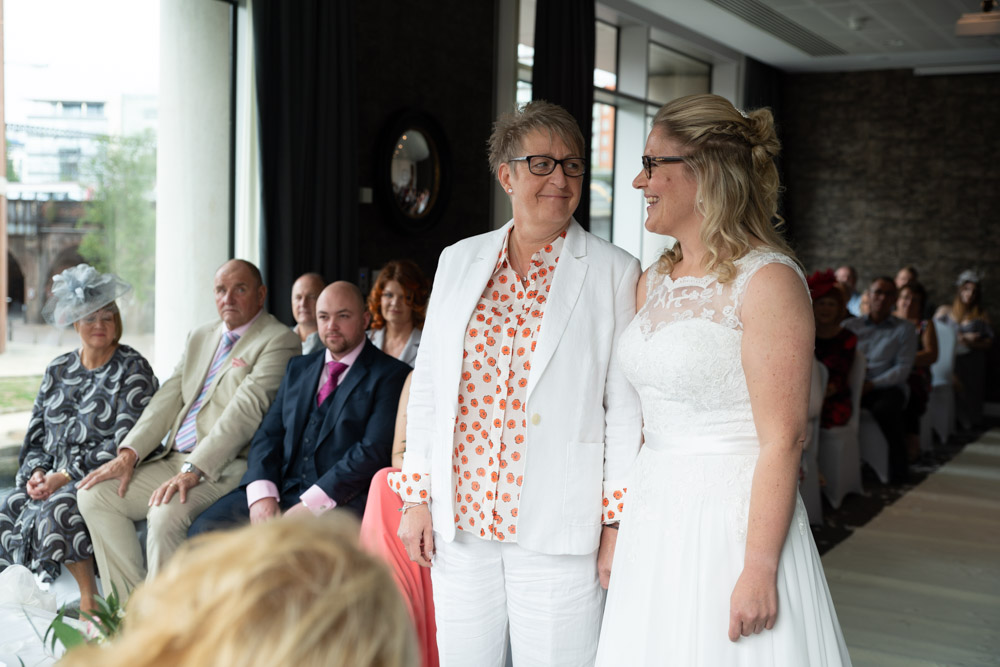 Clare and Tracey exchanging a loving look mid-ceremony