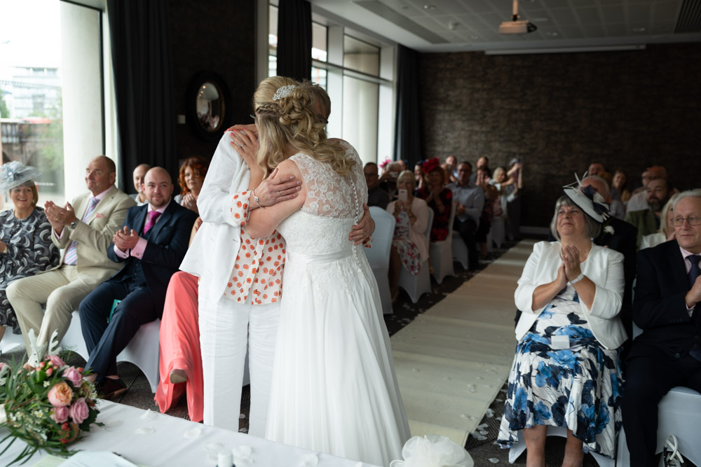 The newlyweds share their first kiss as guests applaud