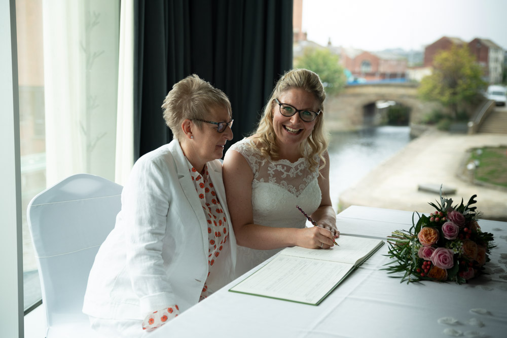 Clare smiling while pretending to sign the register
