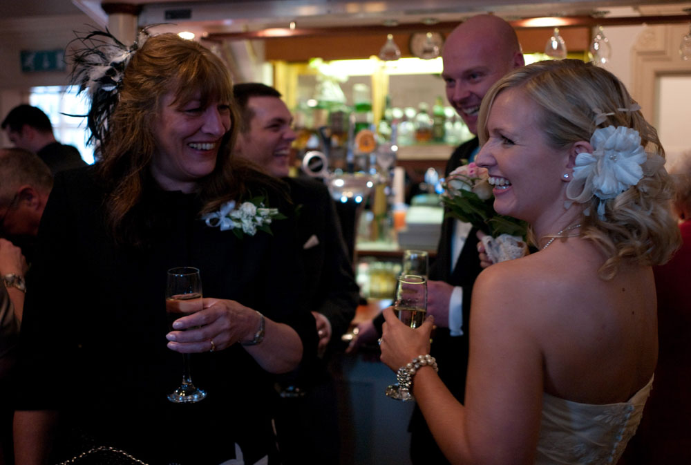 Dani and Scott with their mums and best man, smiling over champagne