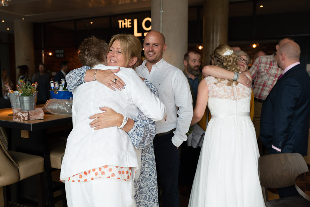 Friends warmly hugging the newlyweds