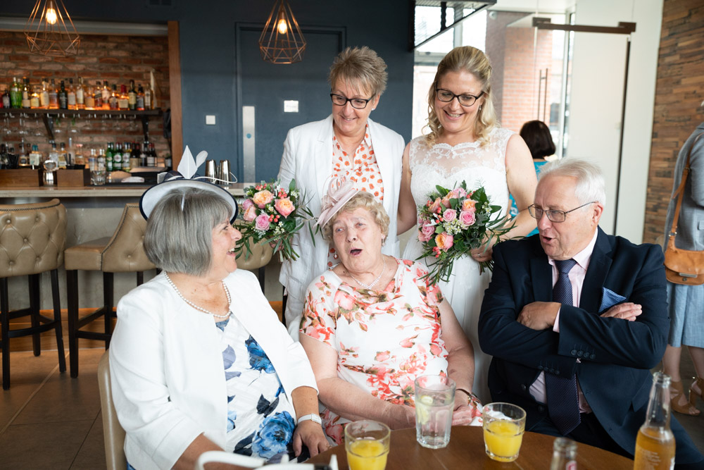 Couple with parents and grandparents in a relaxed group