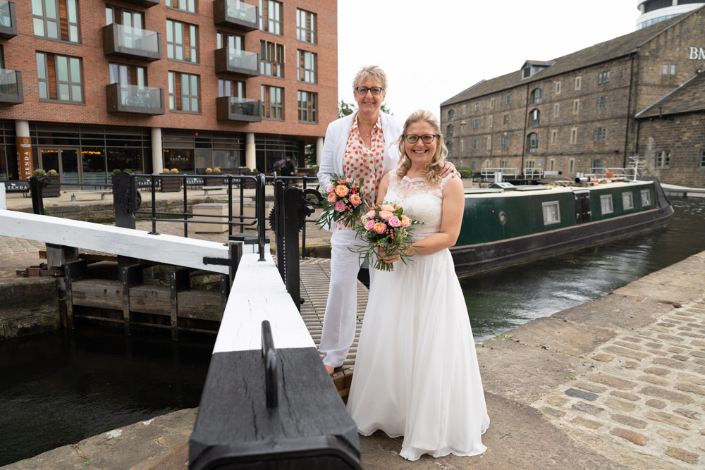 The couple posed on the lock bridge with a canal boat behind