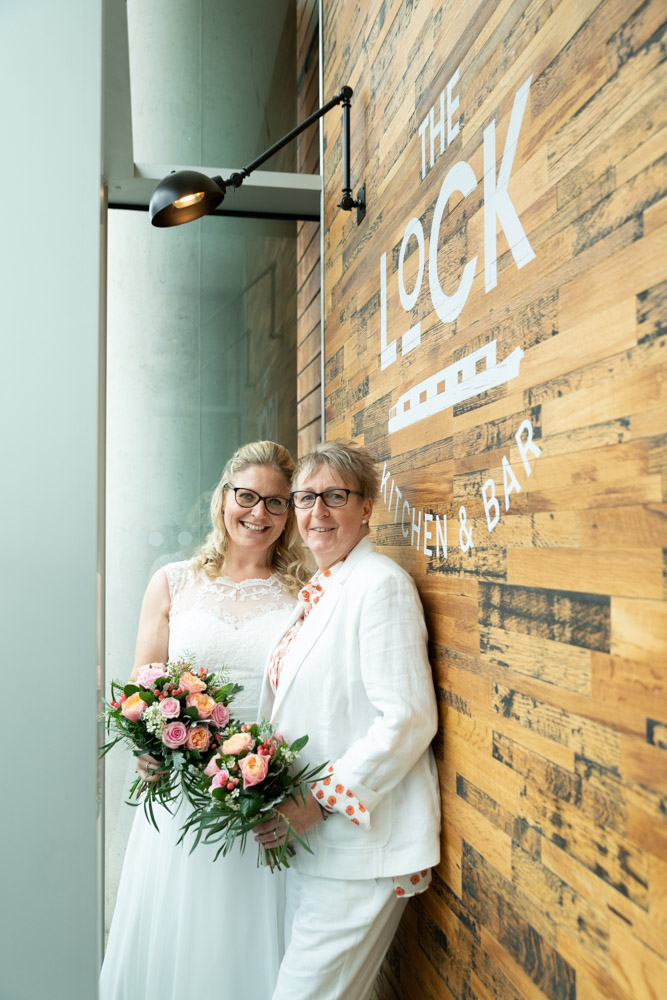 The couple leaning close on The Lock Bar's wooden exterior