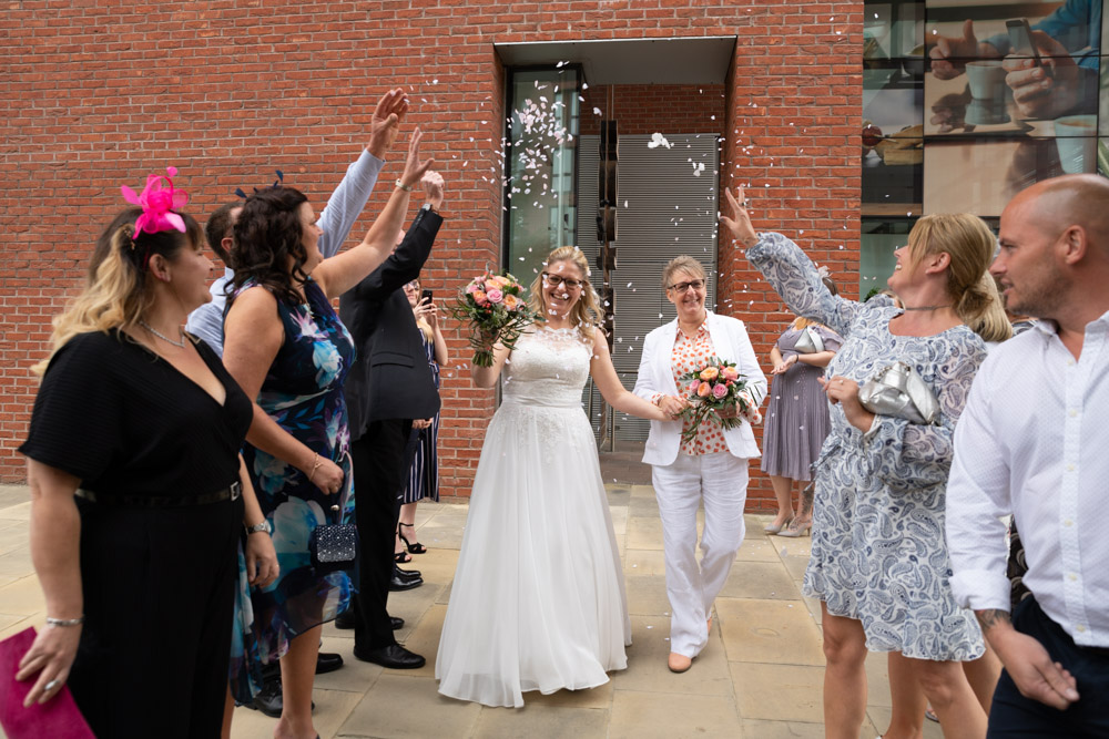 The couple walking through more confetti