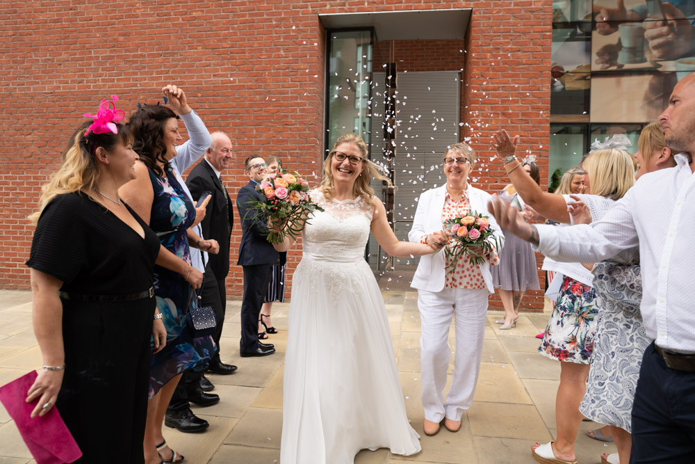 Big smiles as the couple near the end of the confetti aisle