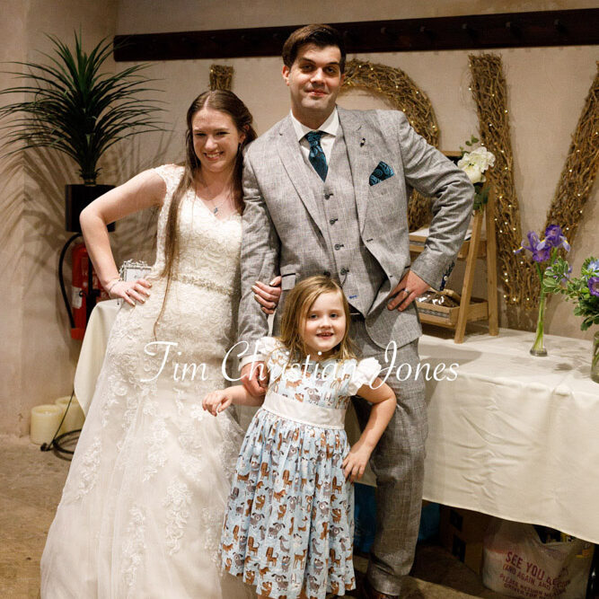 Jane and Callum smiling with their flower girl after the wedding breakfast at The Priest’s House.