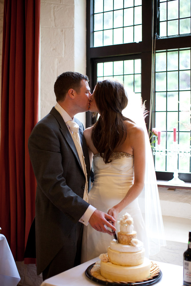 A kiss while cutting the real cheese cake