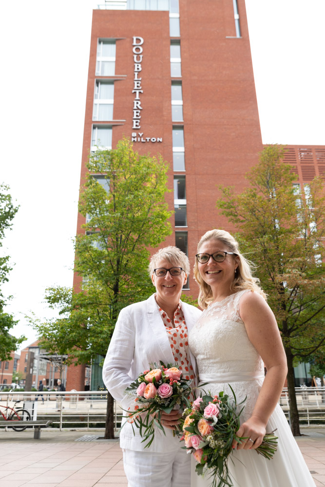 Clare and Tracey smiling with the DoubleTree Leeds behind