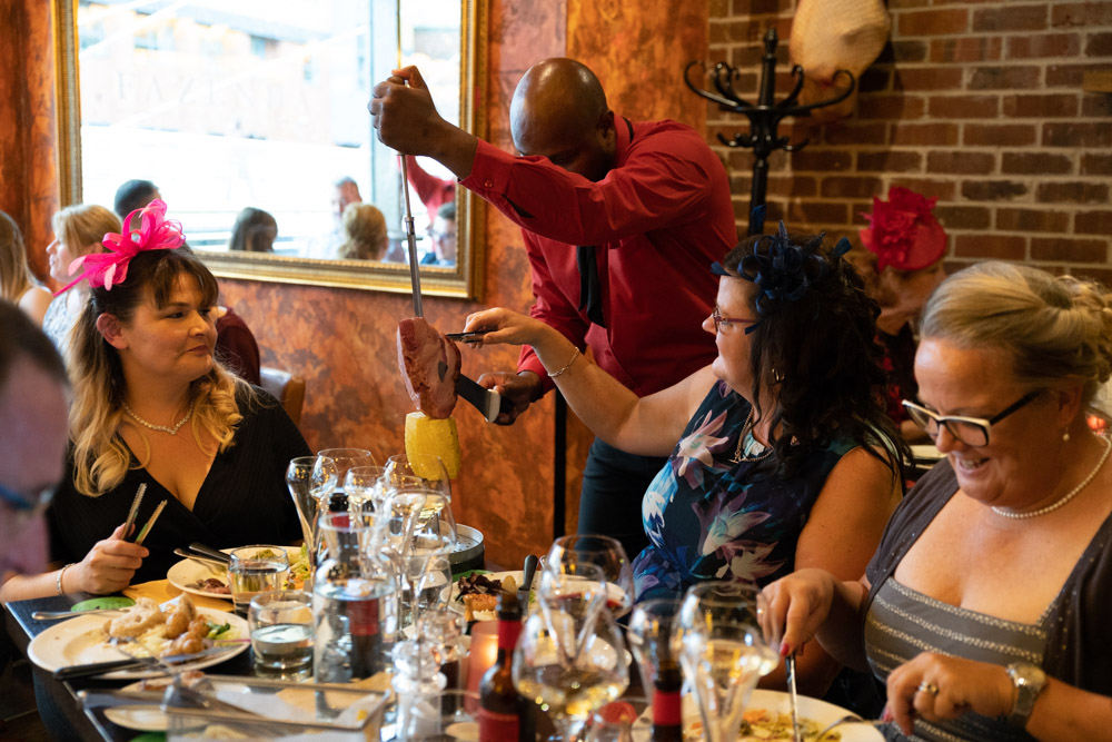 Churrasco meat being served to happy guests