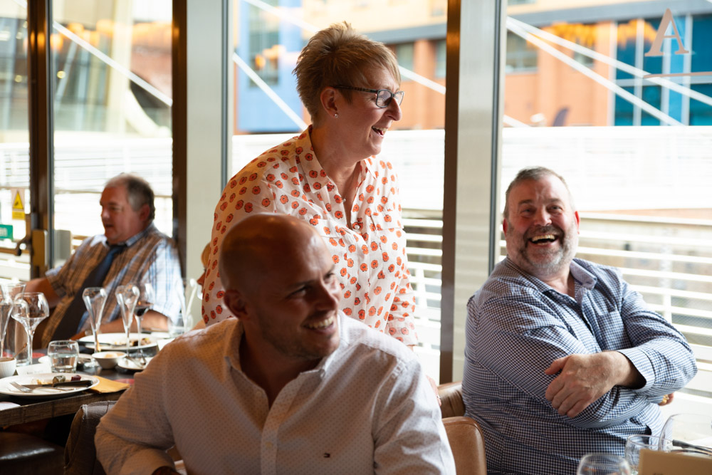 Tracey smiling and chatting with guests at the table