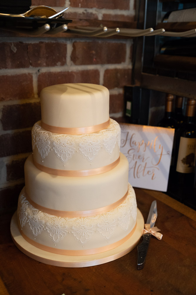 The wedding cake with gold ribbon under soft light