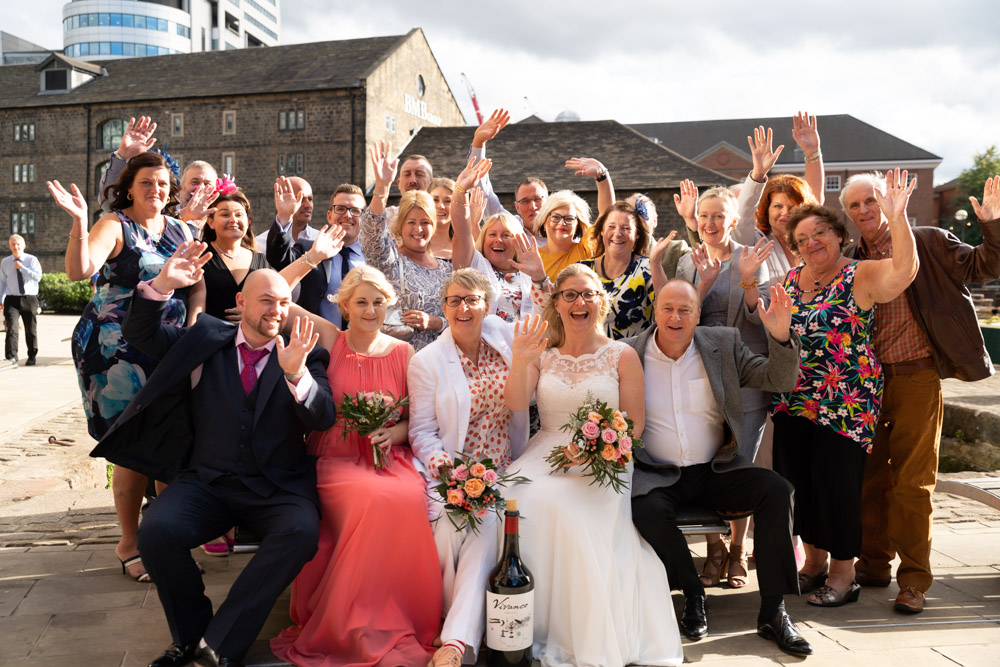 Nearly all the guests waving in a big group shot