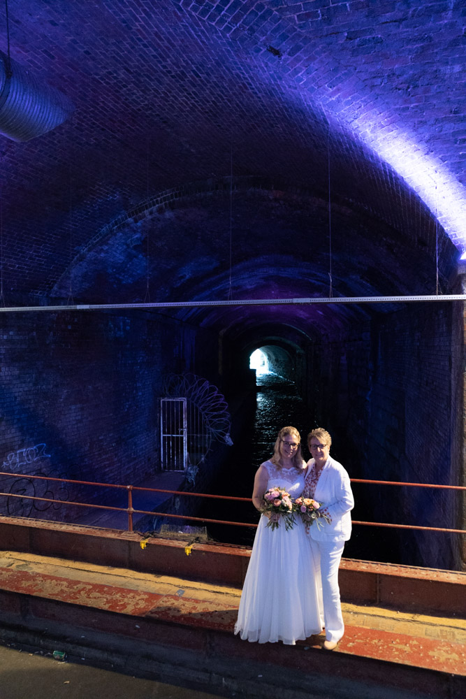 The couple under the Granary Wharf arch glowing blue