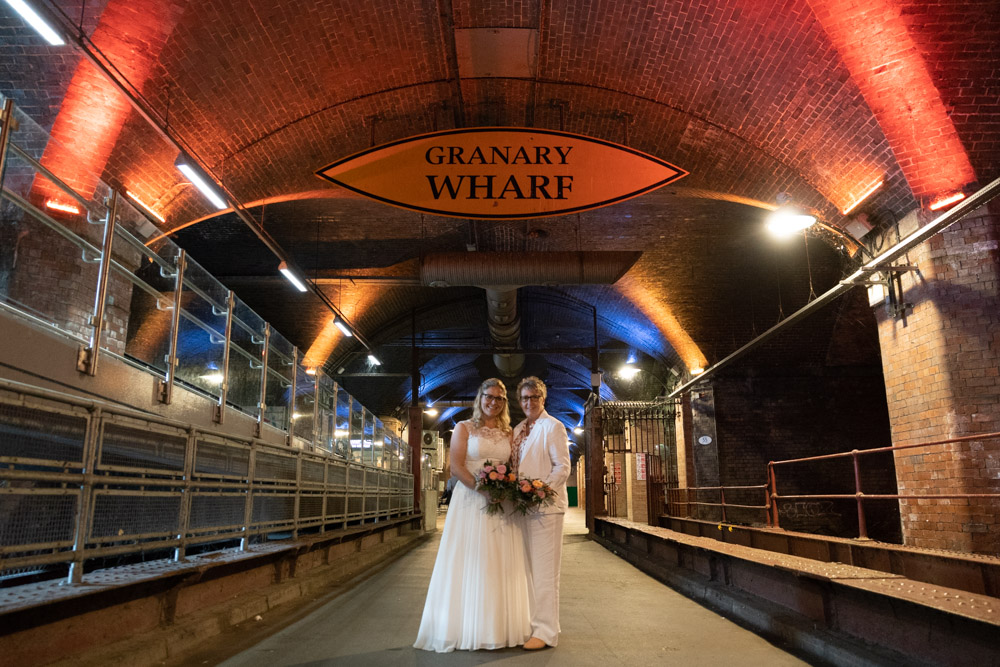 Red lights warm the couple’s smiling faces