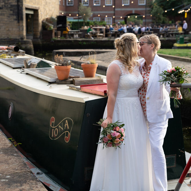 Clare and Tracey share a kiss beside a moored canal boat near DoubleTree by Hilton Leeds.