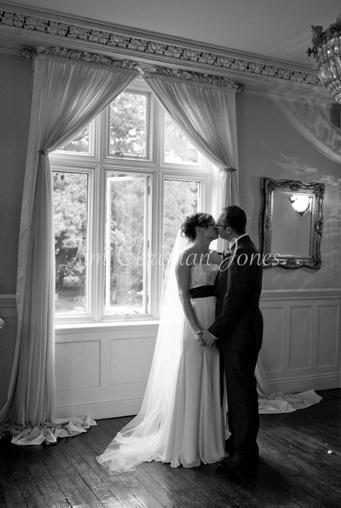 The couple kissing by window light