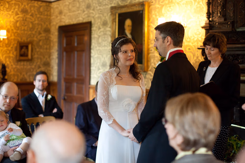Bride reaches her groom as the ceremony begins at Soughton Hall