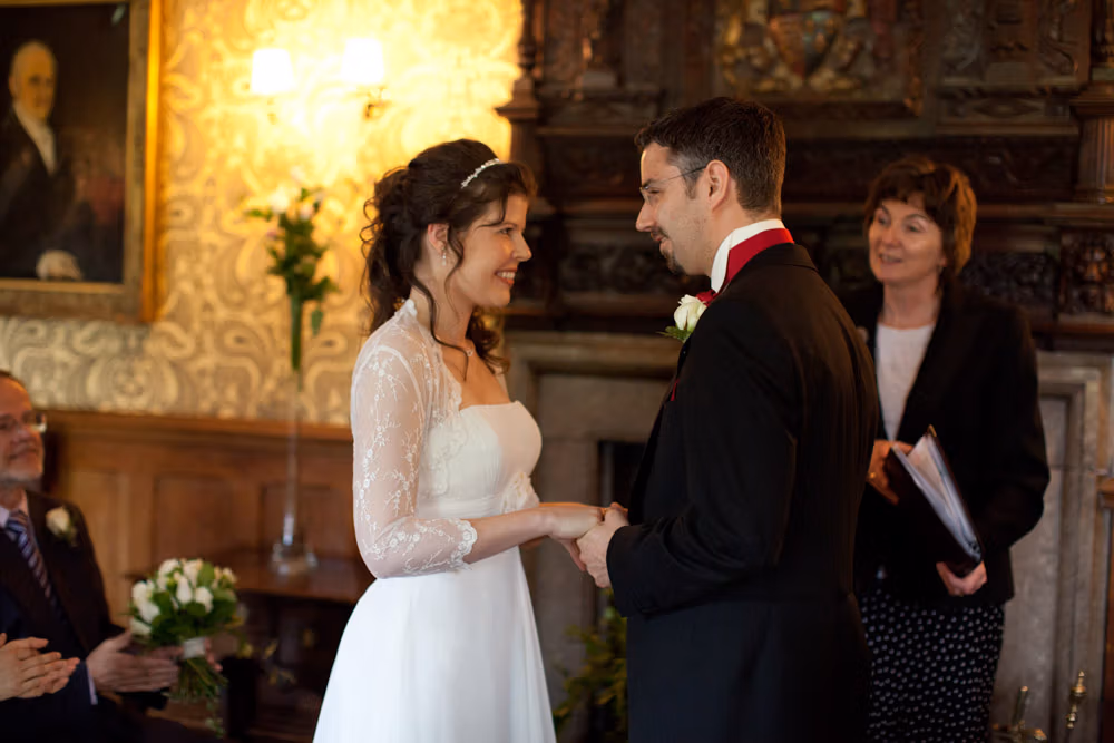 Bride and groom holding hands, smiling with shared emotion after the ceremony