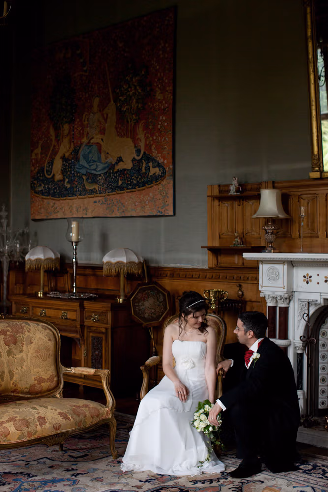 Bride seated and groom kneeling beside her for a quiet, intimate couple moment