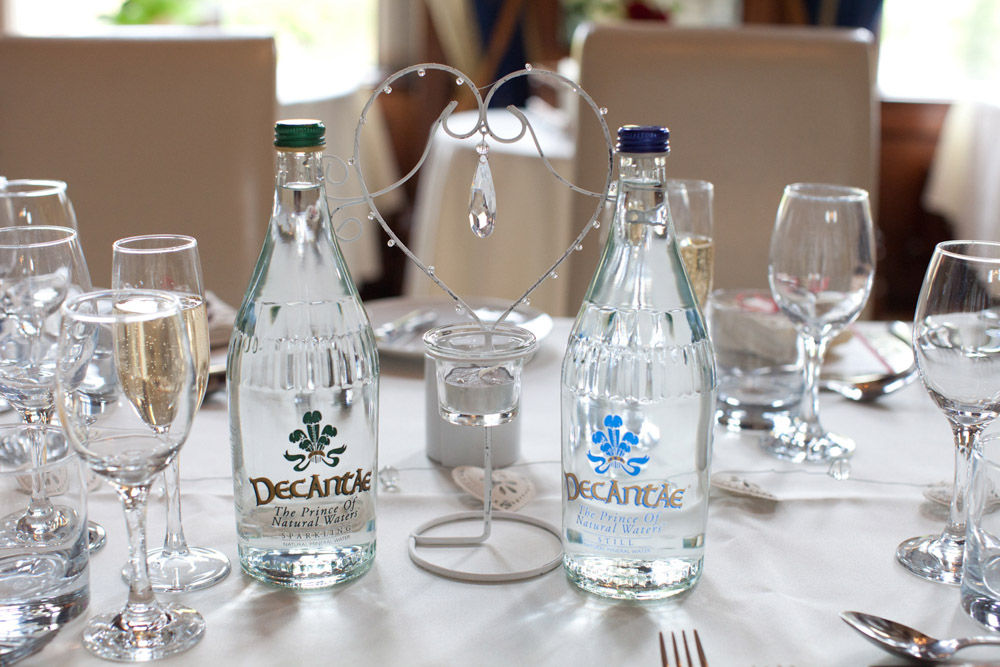 Decanté Welsh spring water served in glass bottles at the wedding breakfast table