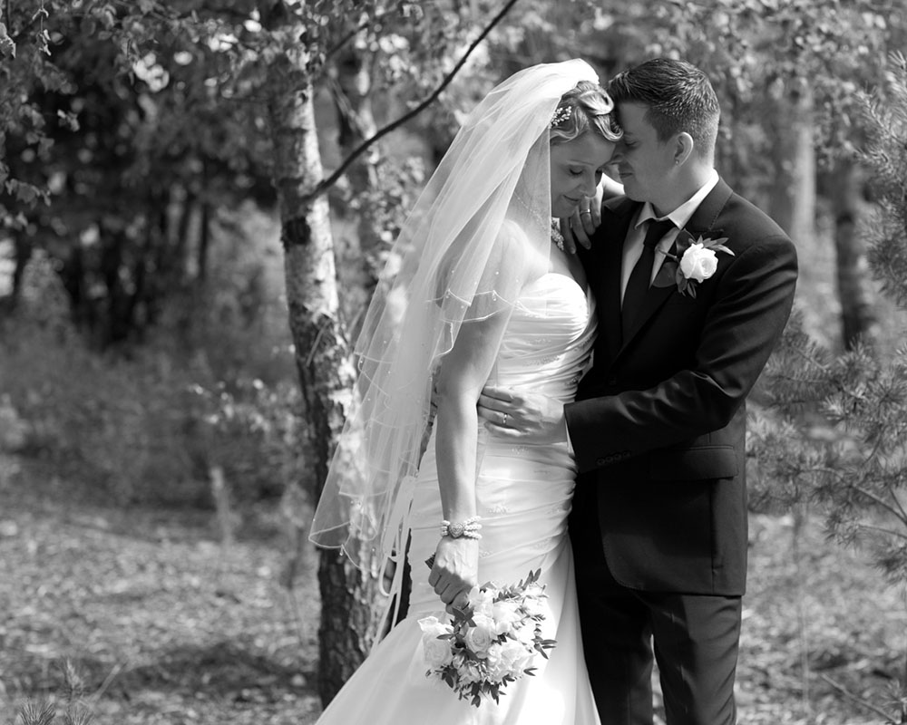 Couple walking through woodland at the KP Club, a peaceful natural wedding portrait.