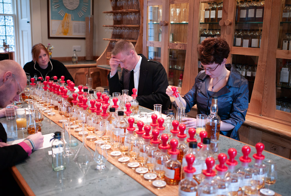Geartsje and Jelger with two friends at Glengoyne Distillery in February, snow falling over the lochs and mountains during their intimate whiskey-tasting elopement
