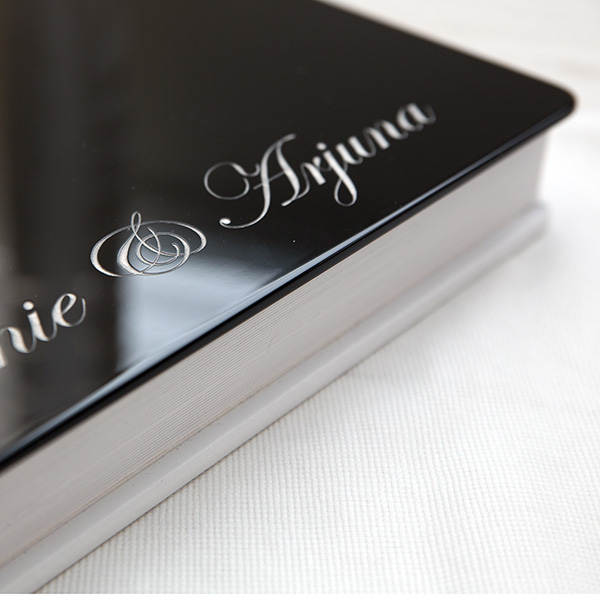 GraphiStudio wedding storybook with white leather cover and black gloss engraved front — modern Italian craftsmanship